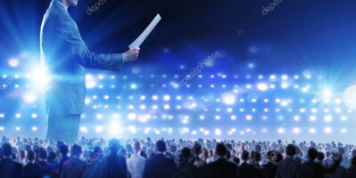 Asistentes y escenario iluminado en conferencia